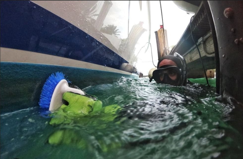 Diver cleaning hull underwater